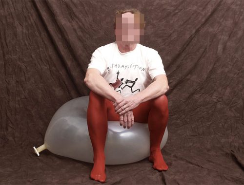 Ein Mann in einer roten Strumpfhose sitzt auf einem Luftballon