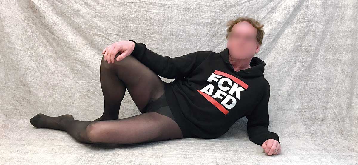 Mann in einer schwarzen Feinstrumpfhose und FCK-AFD-Pulli